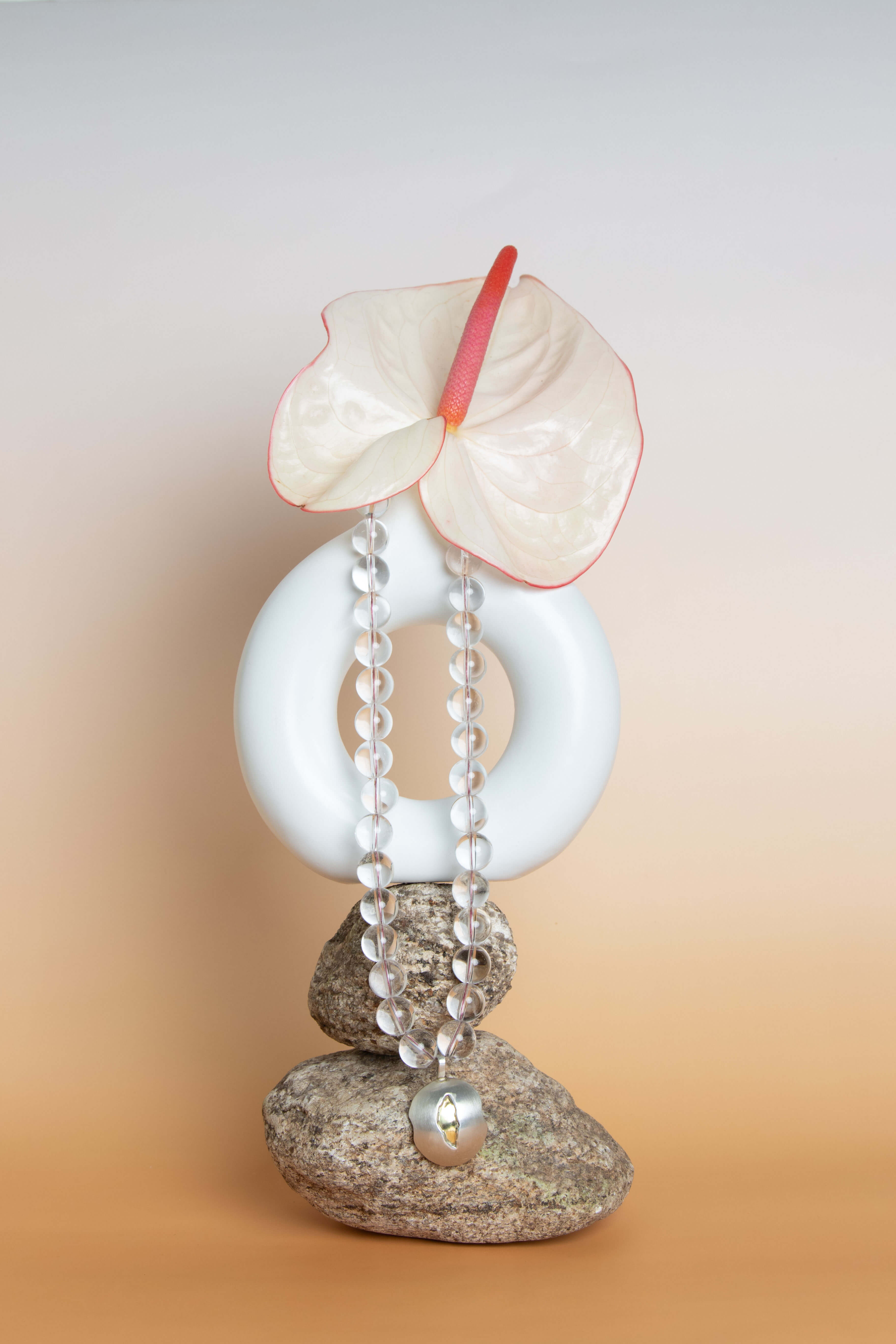 Colar de contas sobre pedras e base arredondada